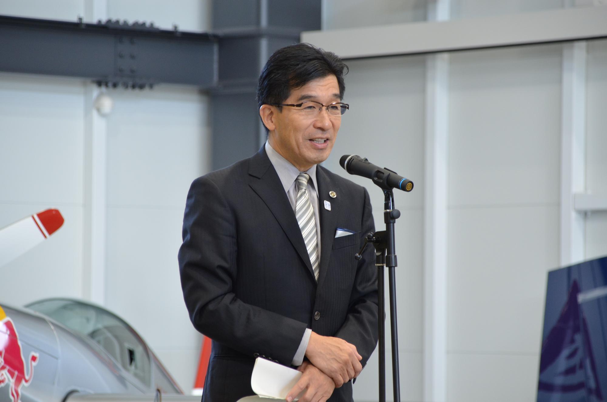 市長がマイクスタンドの前であいさつをしている写真