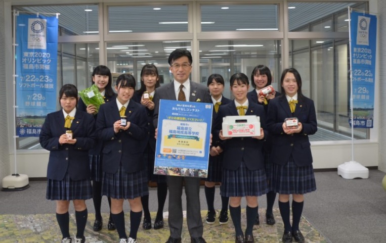 真ん中で市長がパネルを手に持ち、両隣りに女子高生が4名ずつ前後に立って、記念撮影している写真
