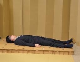 成人男性1人程の大きさの段ボールに大の字で横になっている市長の写真
