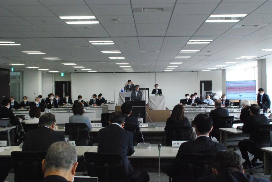 出席者の前で話をしている市長を出席者の後方から撮影した写真