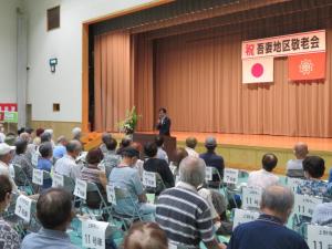 吾妻地区敬老会と書かれた横断幕がある会場で、多くの参加者が座っている前で市長が立って話をしている写真