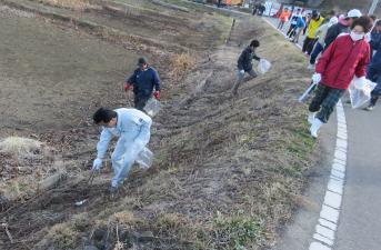 土手や道路沿いに落ちているごみを拾う市長や参加者達の写真