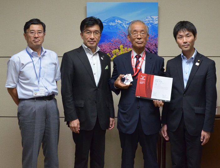 市長とメダルを首に掛けた今野金哉さんと関係者が並んでいる写真
