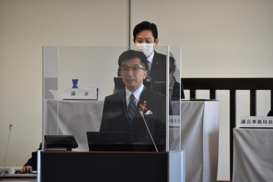 市長がアクリル板で区切られた演台に立って話をしている写真