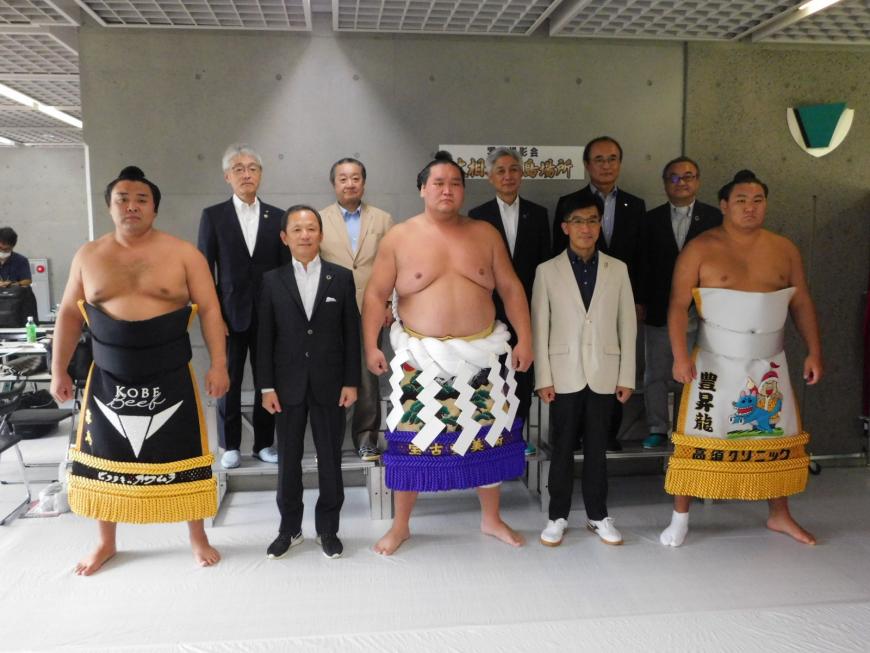 前列の照ノ富士、霧島、豊昇龍の間に市長と男性が立ち、後列に関係者の方が立っている写真