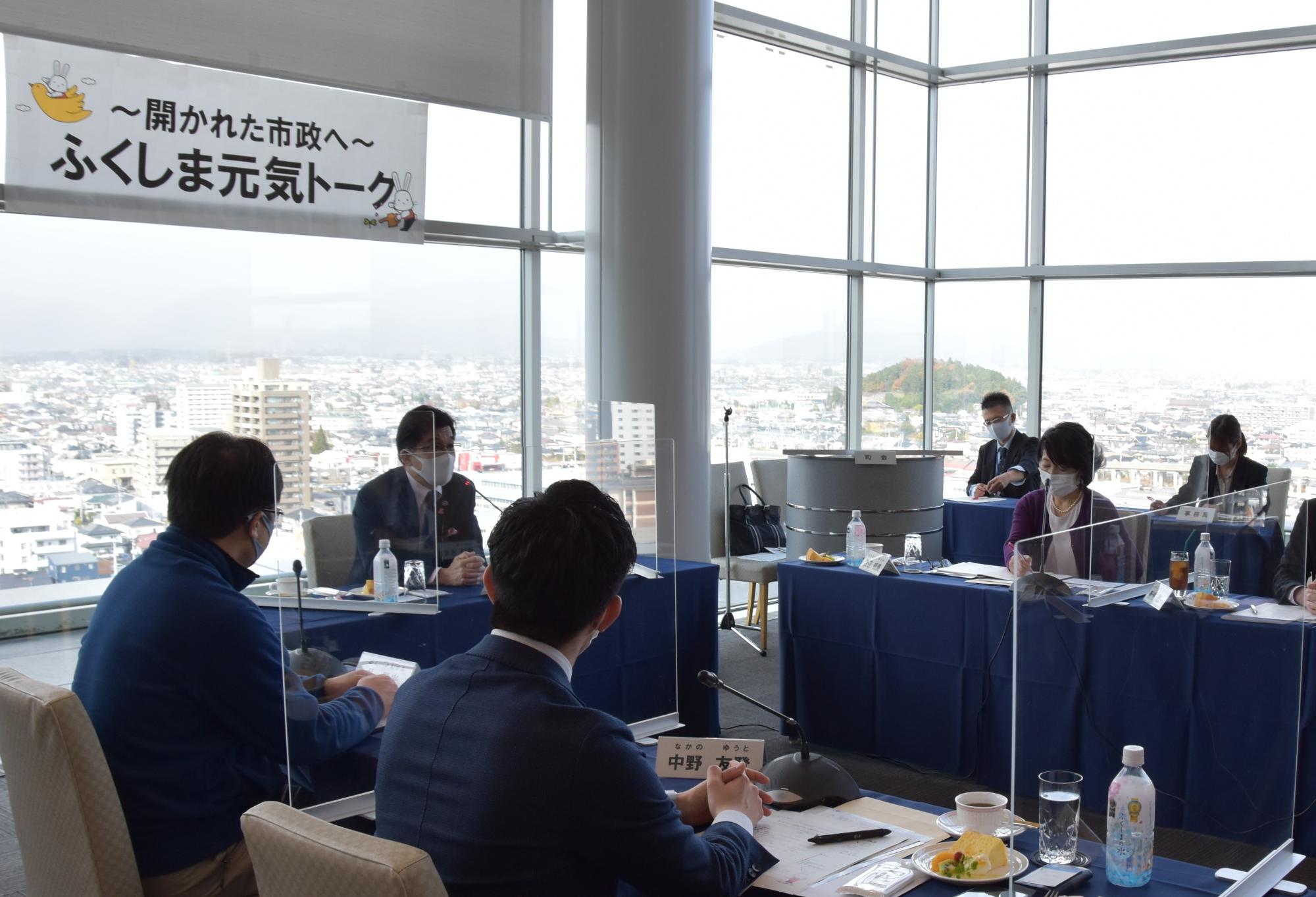 市長と関係者が席に座り、意見交換を行っている写真