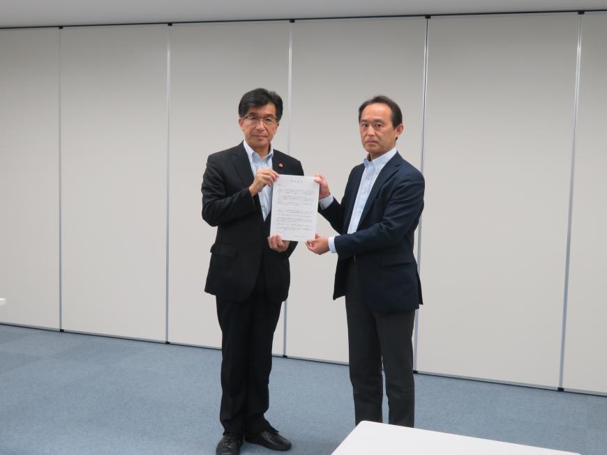 執務室内で市長と男性で要望書を持っている写真