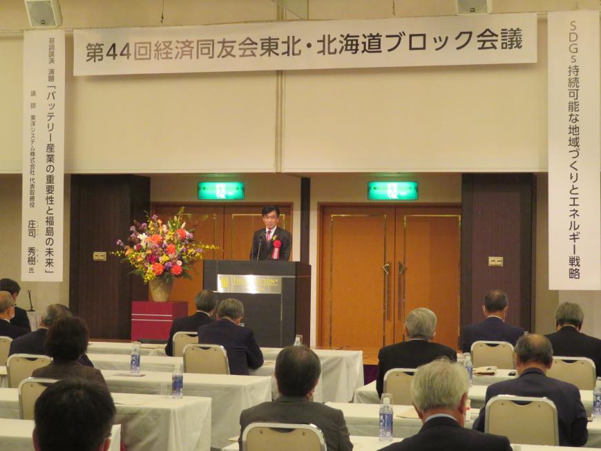 経済同友会東北・北海道ブロック会議の横断幕がある会場で、座っている参加者の前で市長が演台に立って話をしている写真