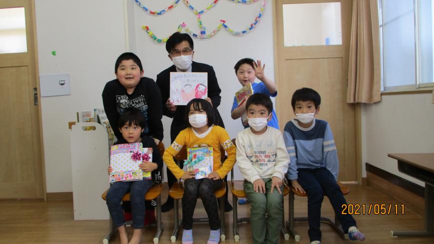 前列に園児が4名椅子に座り、後列には中央に市長とその両隣りに園児が1名ずつ並び記念撮影している写真