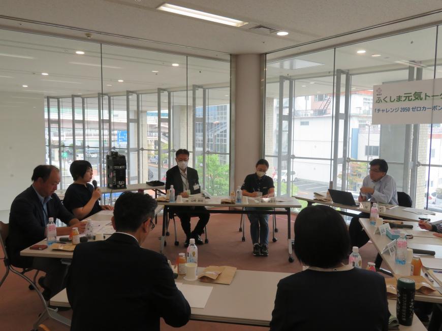 市長を含めた参加者が円形に並べた長机に座り、話をしている写真