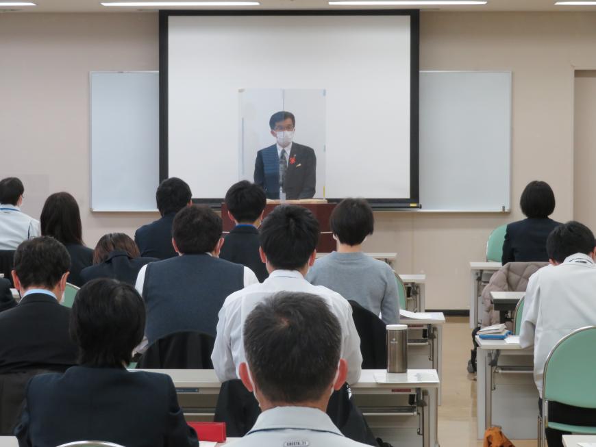 多くの参加者が座っている前で、市長がアクリル板をつけた演台に立って話をしている写真
