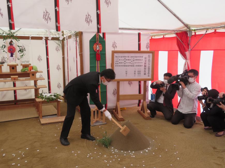 市長が祭壇の前で鍬入れをしている写真