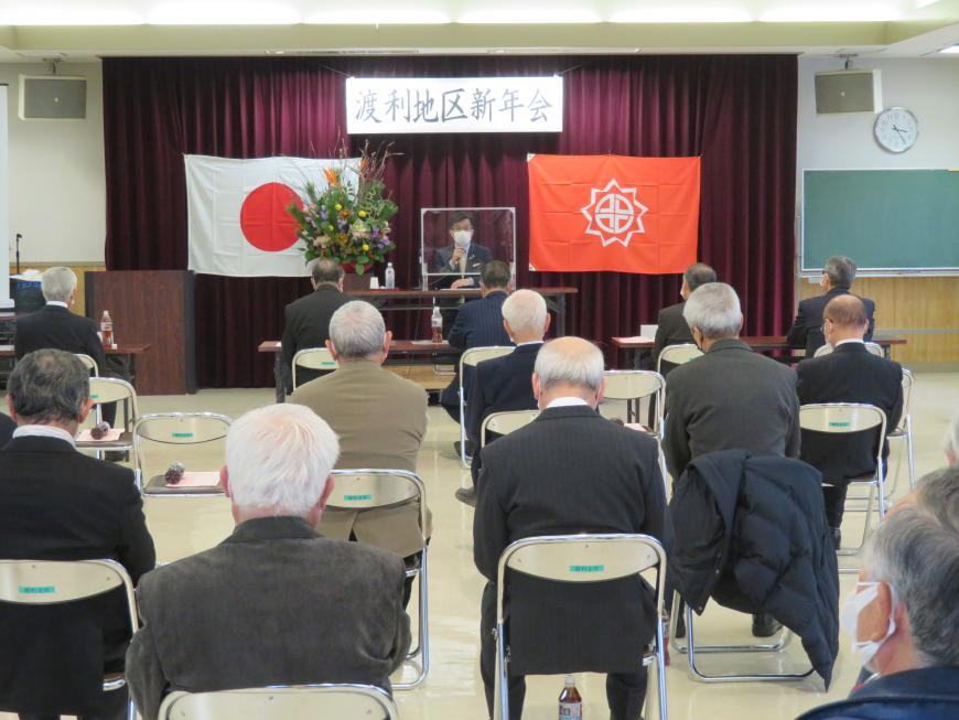 「渡利地区新年会」と書かれた横断幕がある会場で、座っている参加者の前で、市長が話をしている写真