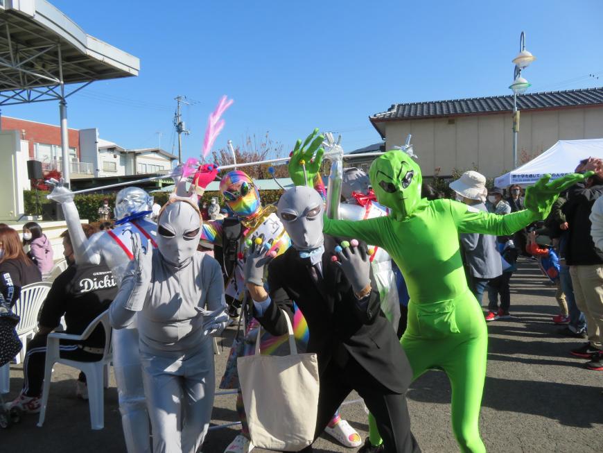 宇宙人に仮装した5人ほどが集まりカメラに向かってポーズを決めている写真