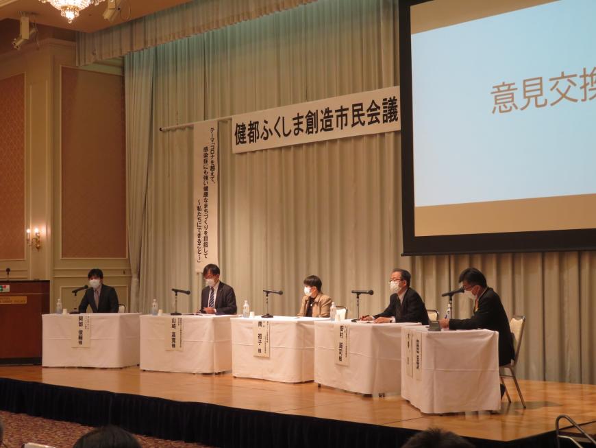 ステージに市長を含めた5名のパネラーが座っている写真