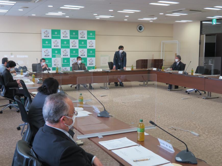 四角の形に配置された机に参加者が座り、市長が自席で立って話をしている写真