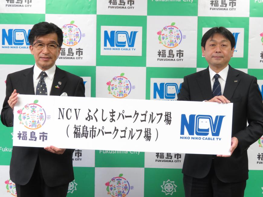 バックパネルの前で、市長と男性で「NCVふくしまパークゴルフ場」と書かれたボードを持っている写真