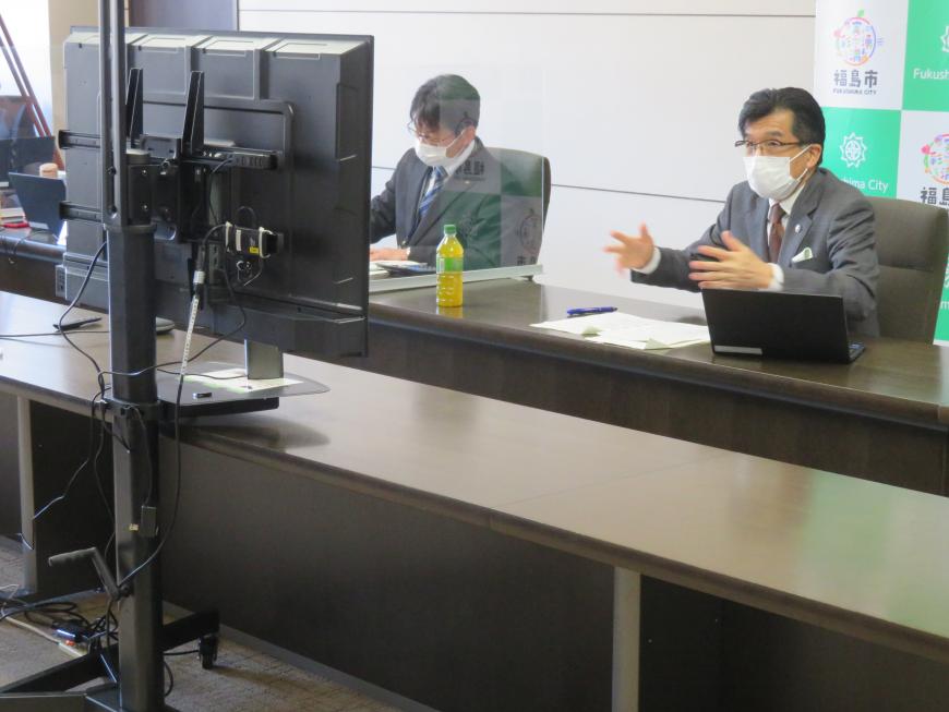 市長がパソコンのモニターを見ながら話をしているところをモニター後方から撮影した写真
