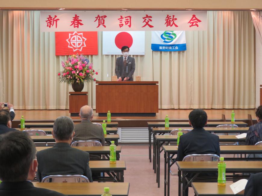 新春賀詞交歓会にて座っている参加者の前で、市長が演台に立って話をしている写真