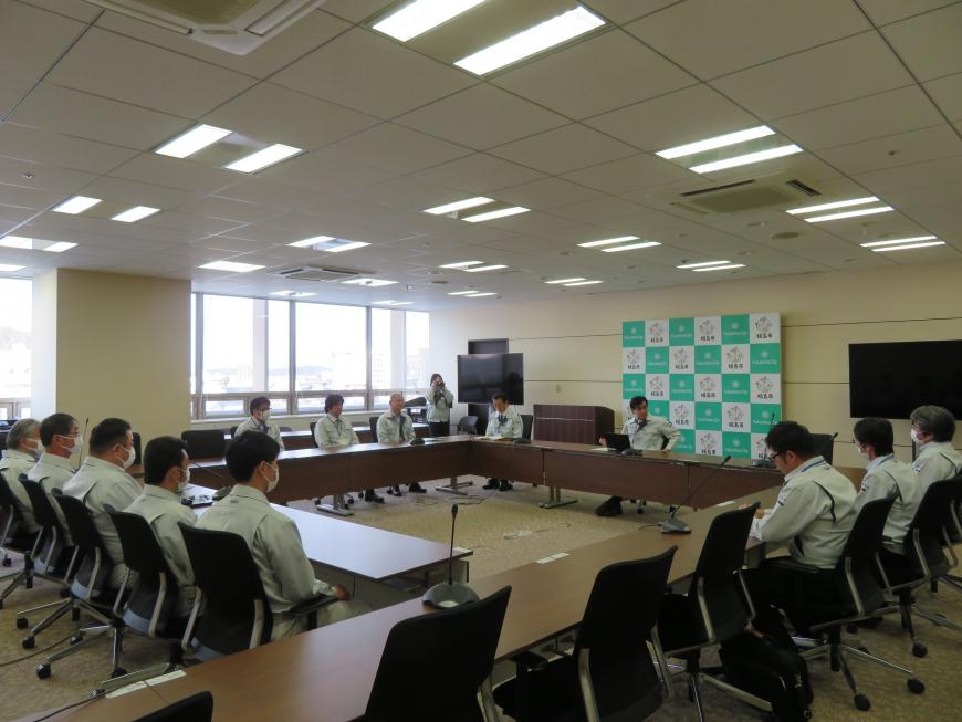 ロの字型に配置された机に市長や他の職員たちが座り、話をしている写真