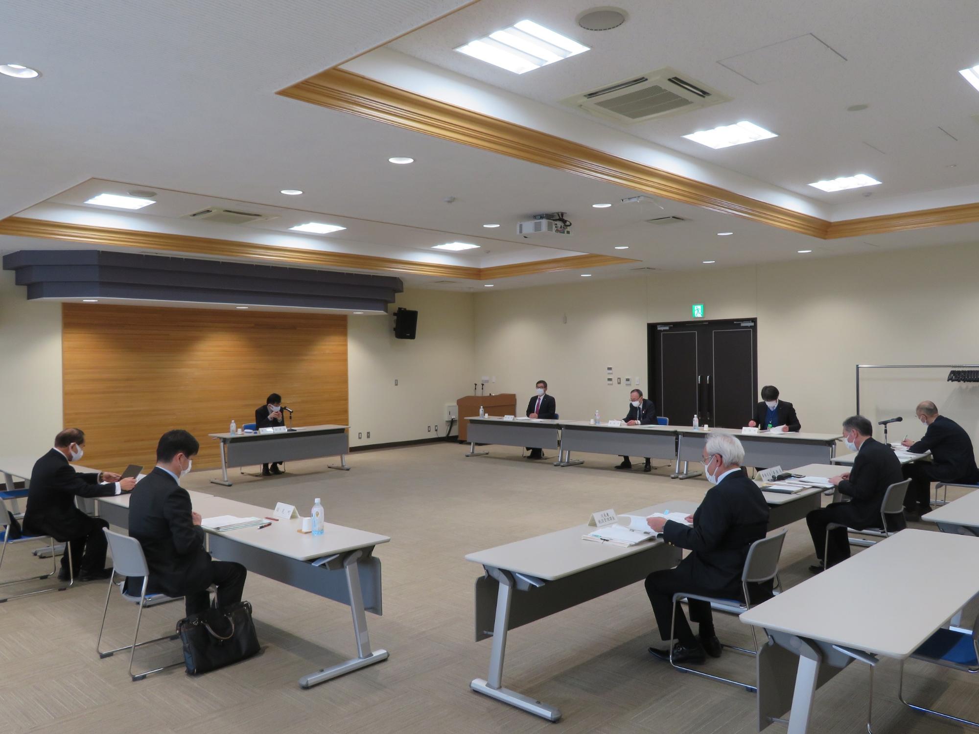 コの字型に並べられた机の席に座り、協議を行っている写真
