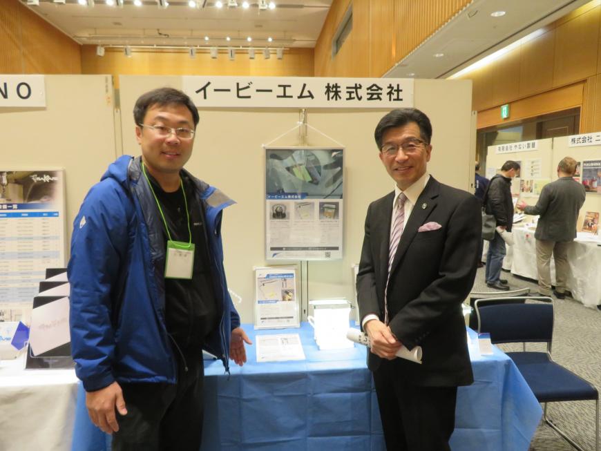 「イービーエム株式会社」の看板があるスペースに市長と男性が並んでいる写真