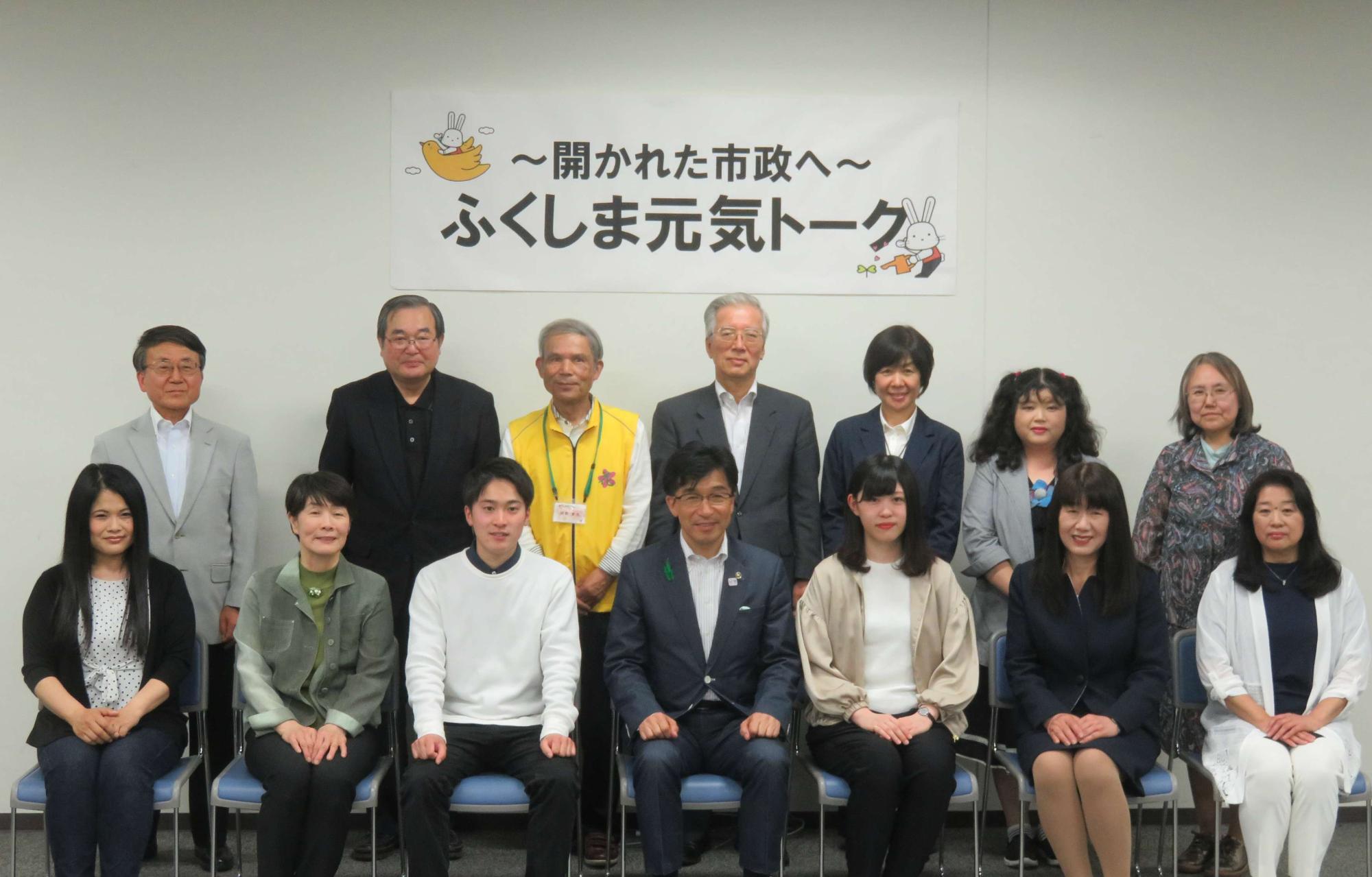 「~開かれた市政へ~ふくしま元気トーク」と書かれた紙が貼られた壁の前で市長と関係者が2列に並び記念撮影をしている写真