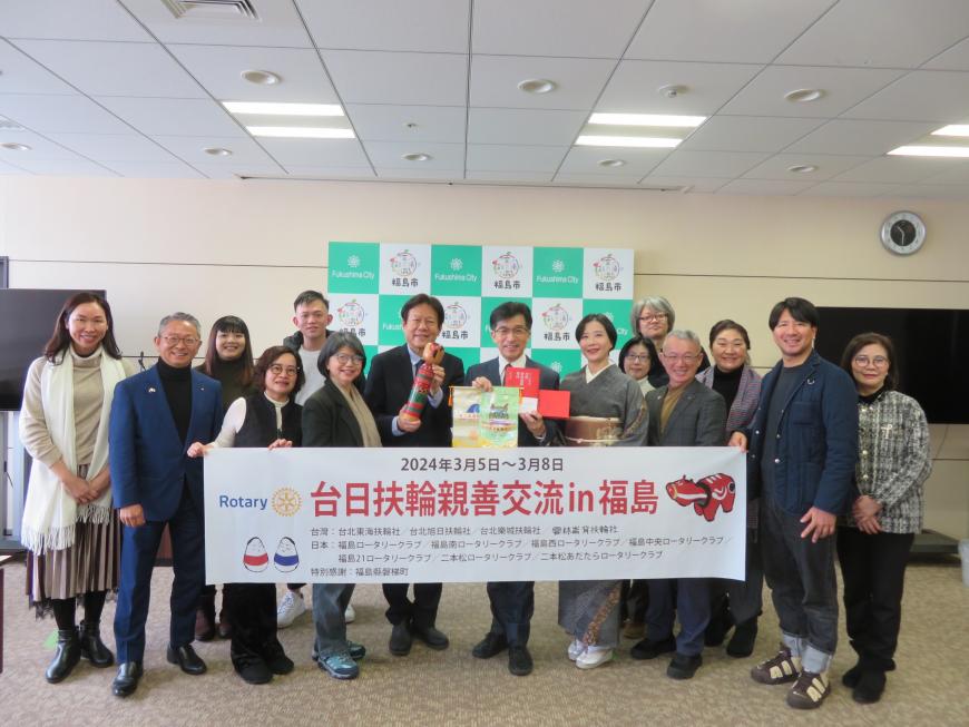 バックパネルの前で、「台日扶輪親善交流in福島」と書かれた横断幕を持ち、市長を含めた多くの男女が並んでいる記念写真