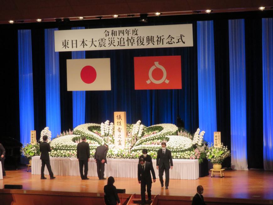 犠牲者之霊の祭壇に一人一人がステージにあがり礼をしている写真