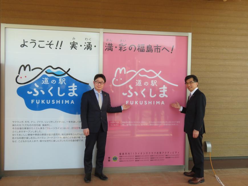 「道の駅ふくしま」の巨大パネルの横に市長と男性が立ち、手を添えている写真