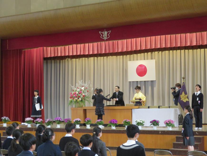 ステージで卒業証書授与が行われているところを後方から撮影した写真