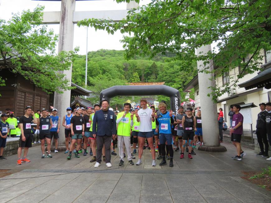 鳥居の下に集まった参加者の前に市長と関係者の方が立ちピースサインをしている写真