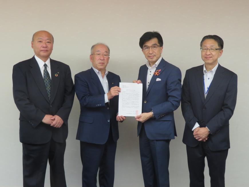 市長と男性が一緒に要請書を持ち、その両脇に男性が1名ずつ立ち、記念撮影している写真