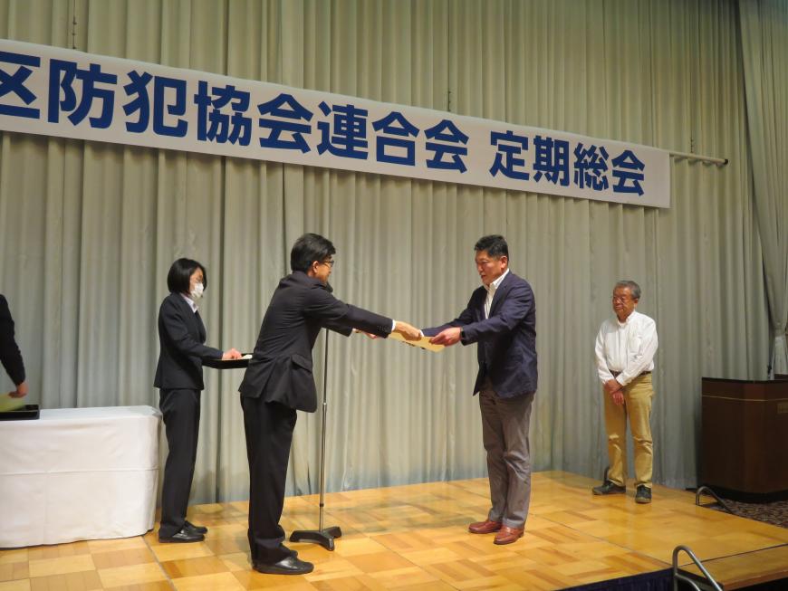 ステージで市長が男性に賞状を渡している写真