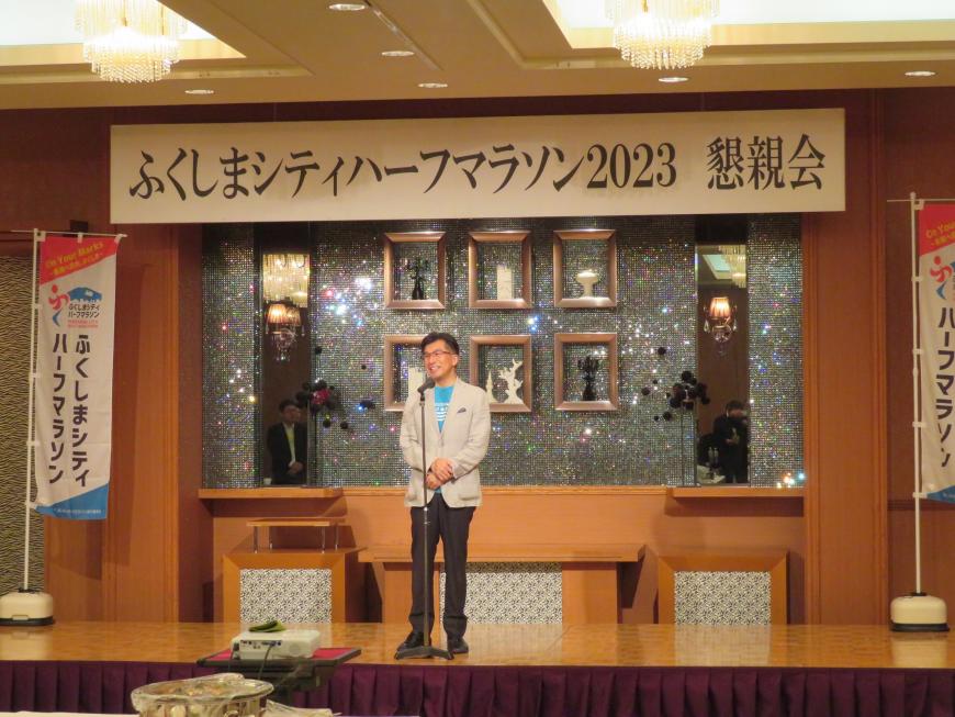 「ふくしまシティハーフマラソン2023懇親会」と書かれた幕があるステージで、市長が話をしている写真