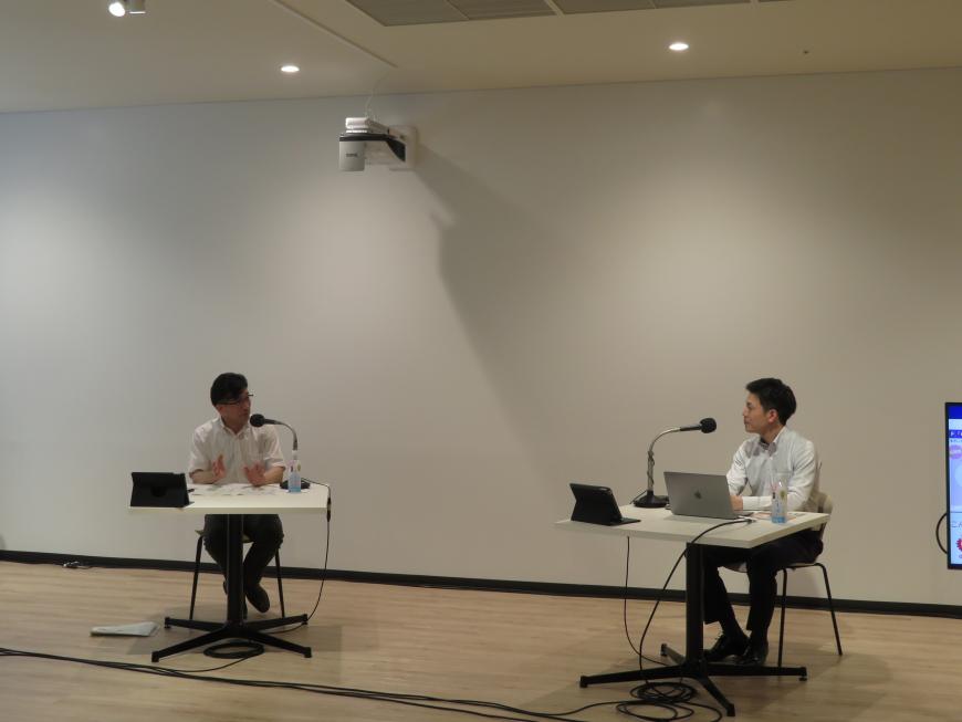 1人用の机に座った市長と男性が話をしている写真