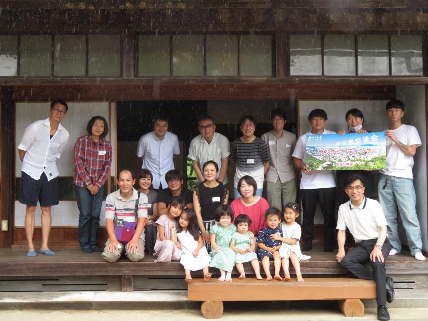 古い家の縁側でミーティングに参加した大人14人、子供6人、市長が並んで撮影した写真