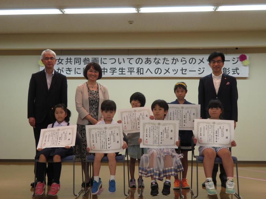 表彰された児童6人がそれぞれ賞状を持ち、前列4人が座り、後列に2人と市長と男女1人が立っている写真