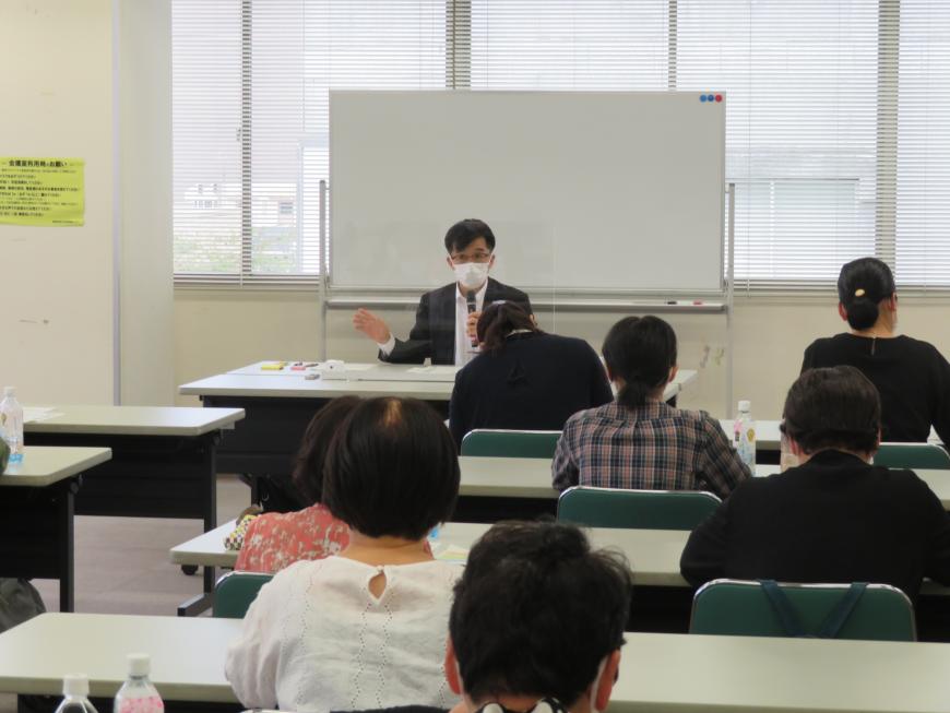 長机に座っている参加者の前で、市長が話をしている写真