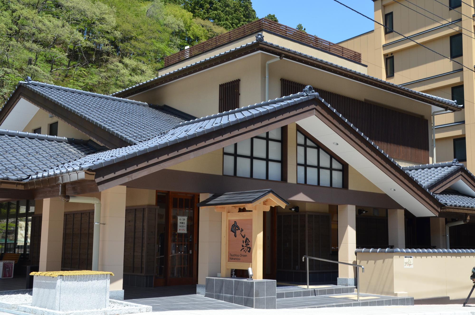 ベージュの壁にグレーの瓦屋根の2階建ての中之湯全景写真