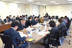多くの参加者が長机にすわり、資料を読んでいる写真