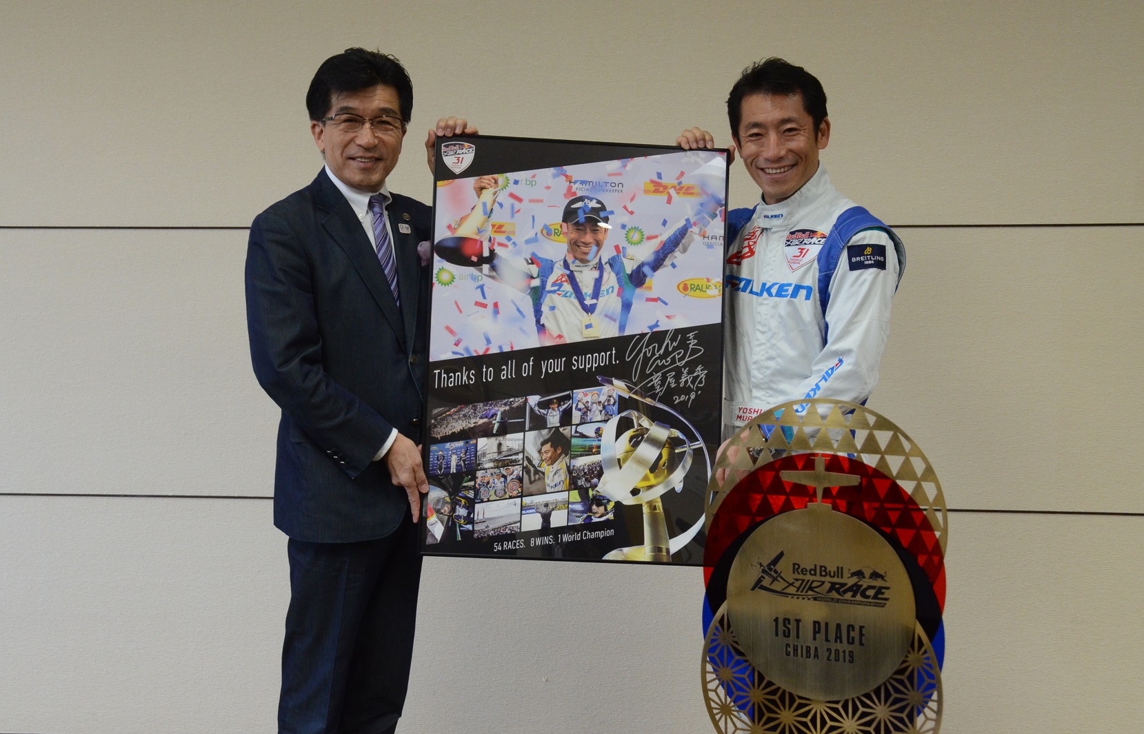 市長とエアレース・パイロットの室屋義秀さんがレッドブル・エアレース・ワールドチャンピオンシップ2019で総合準優勝の宣伝ポスターパネルを持ち記念撮影している写真