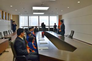 会議机の向かいに座った選手たちに立ち上がって話をしている市長の写真