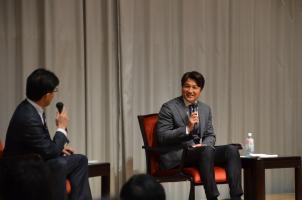ステージ上で左側に座っている男性と、高橋由伸氏が笑顔でトークを繰り広げているトークショーの様子の写真