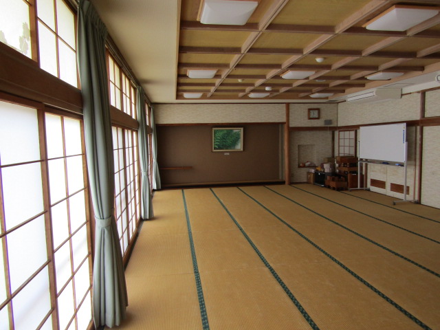 畳張りの部屋の右奥入り口近くにホワイトボードがある和室の室内全体を写した写真