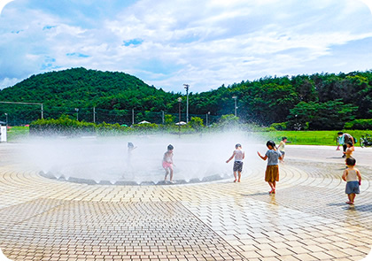 噴水で遊ぶ子供たちの写真