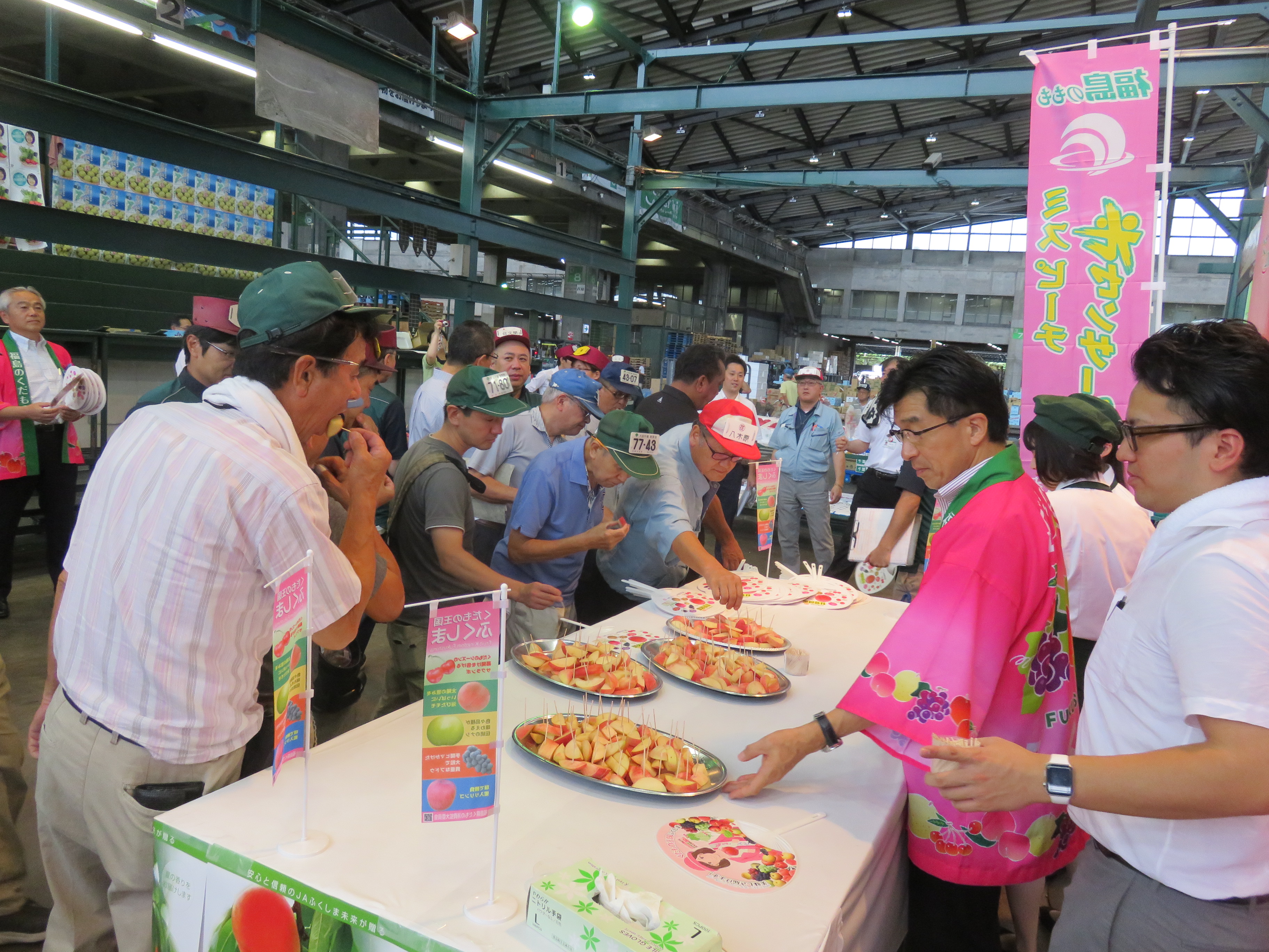 大田市場でモモの試食を勧める市長