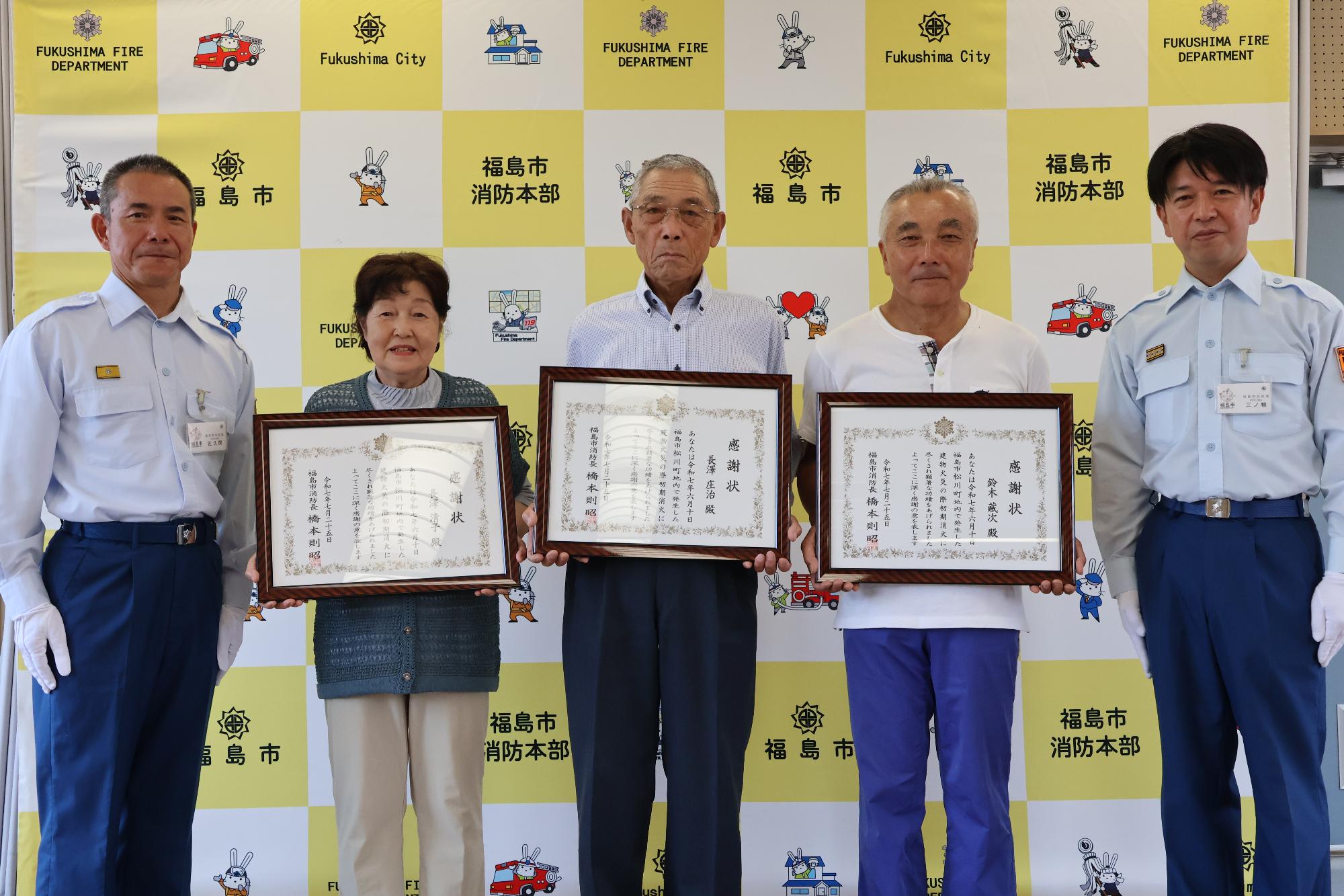被表彰者3名が感謝状を持って福島南消防署長と副署長の5人で記念写真