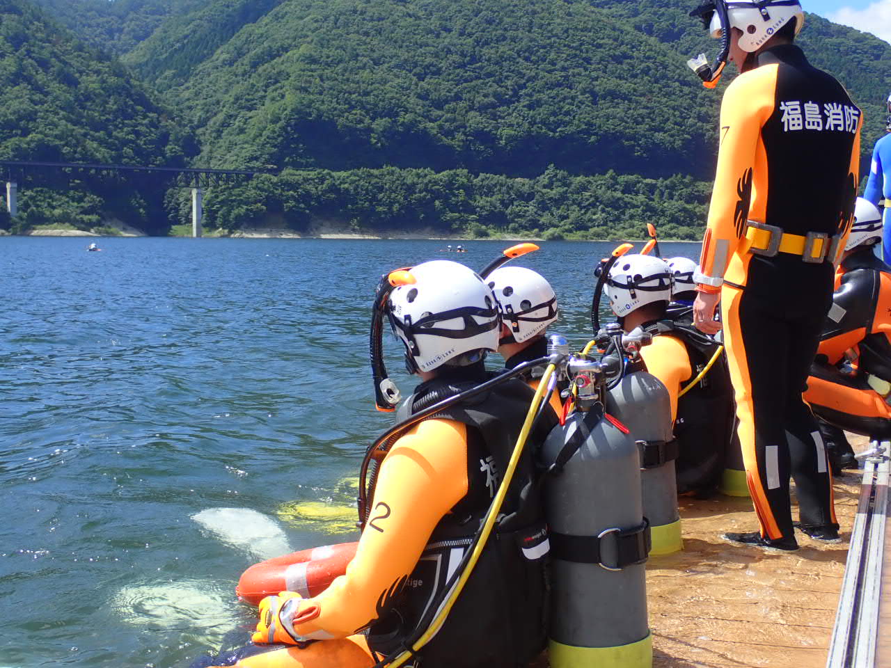 水難救助隊が摺上川ダムの桟橋から湖面を見つめる様子