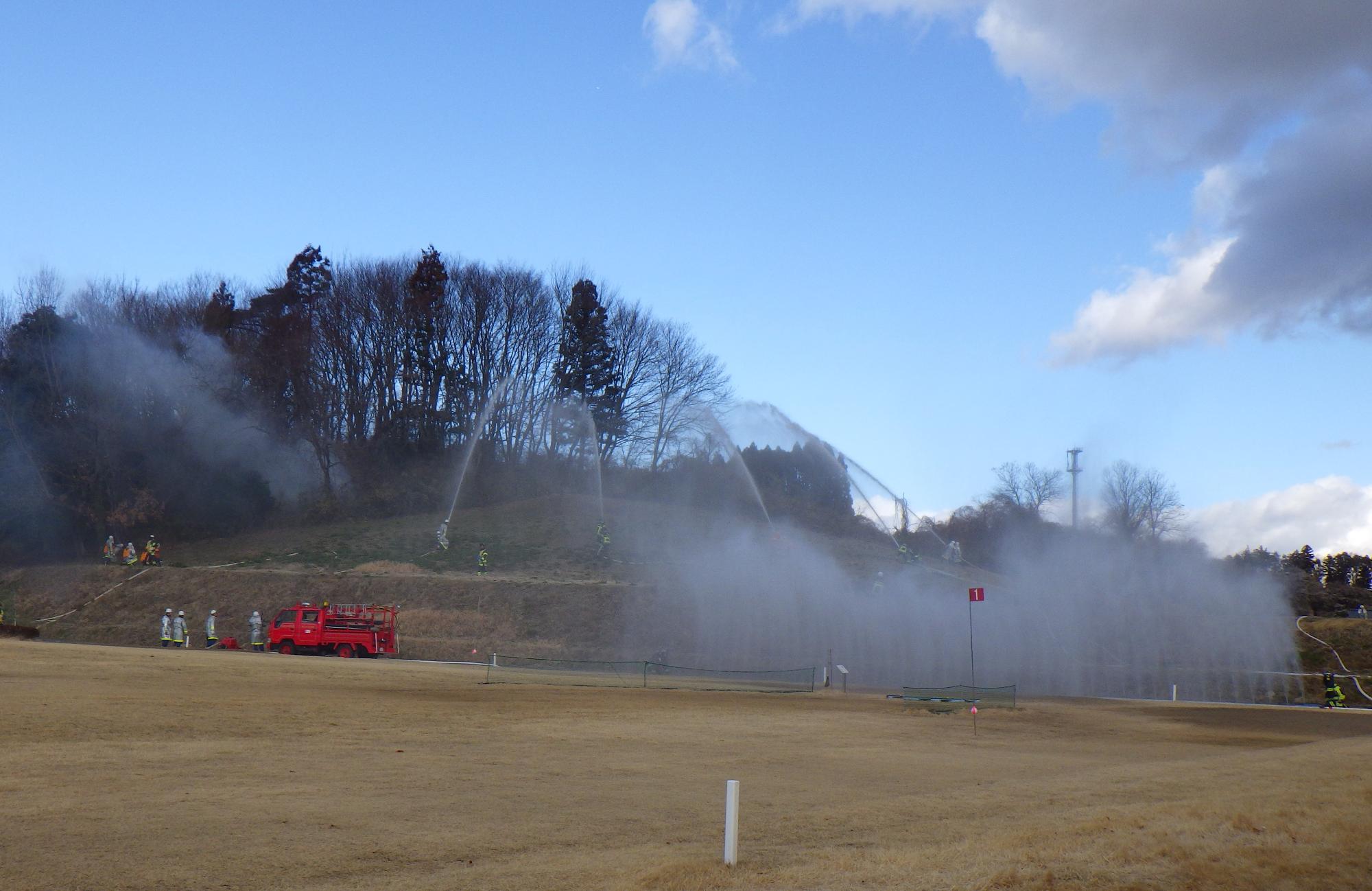 消火隊による5か所一斉放水と水幕による消火訓練をしている写真